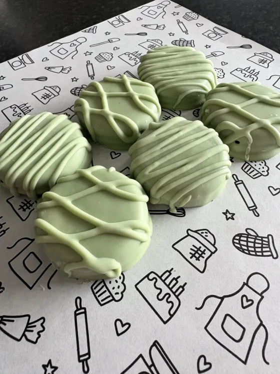Lichtgroene gedipte koekjes met witte streepjesversiering