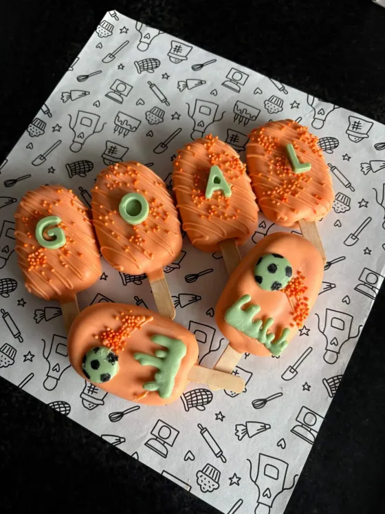 Oranje cakesicles met voetbalthema en de letters GOAL