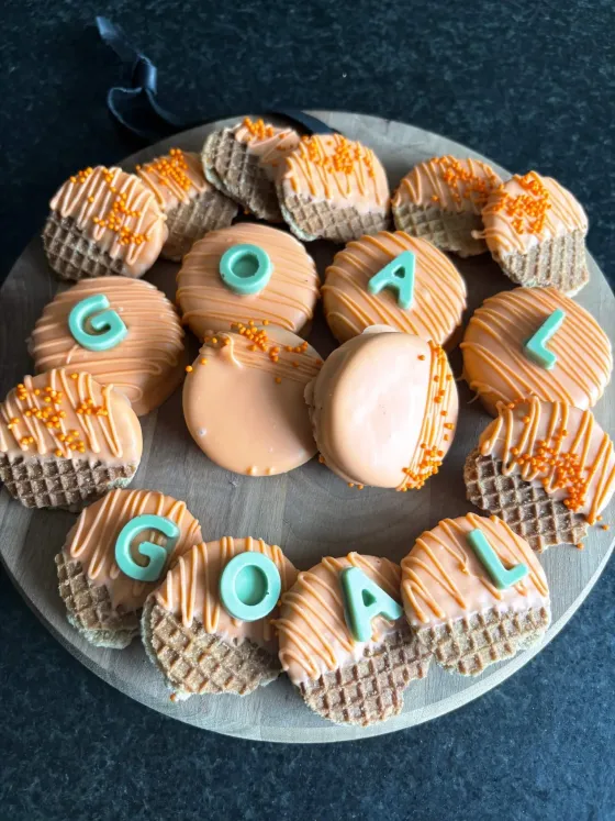 Oranje gedipte koekjes met voetbalthema en de tekst GOAL