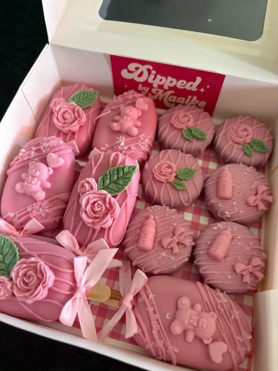 Roze gedipte cakepops met roosjes-versiering in een cadeaubox